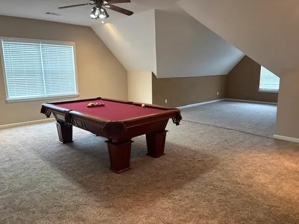 a room with pool table and windows
