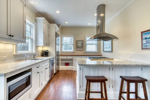 a kitchen with stainless steel appliances a sink a stove and a wooden floors