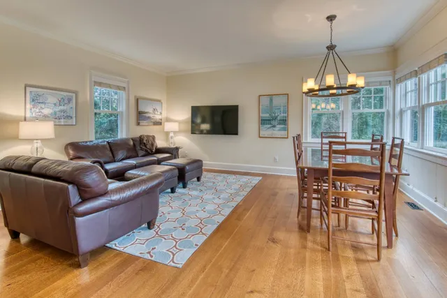 a living room with furniture wooden floor and a chandelier