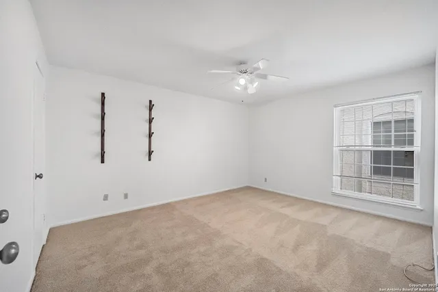 an empty room with a ceiling fan and closet area