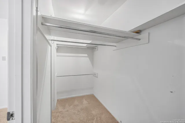 a bedroom with a large bed and a ceiling fan