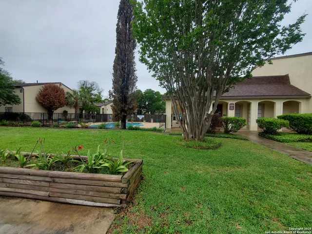 a view of a house with backyard and sitting area