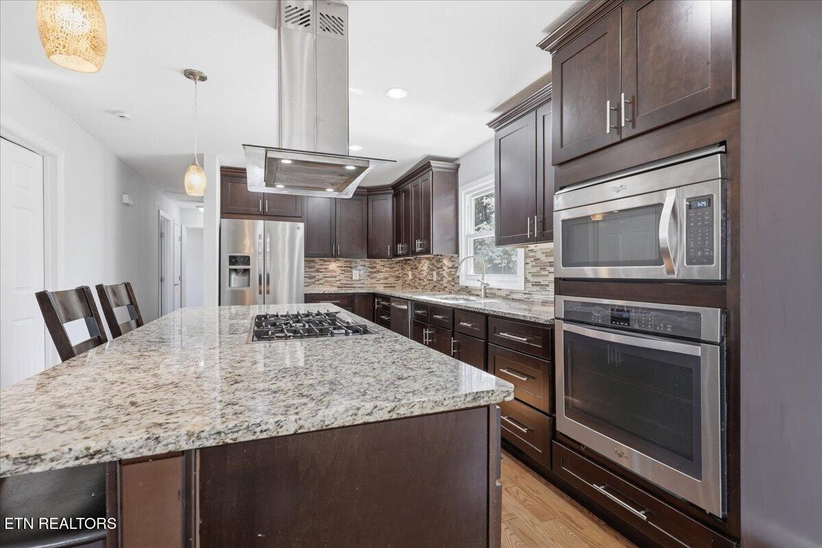 7709 Morris Road Knoxville, TN 37938 - Photo 16 of 52 a kitchen with kitchen island granite countertop a stove cabinets and microwave