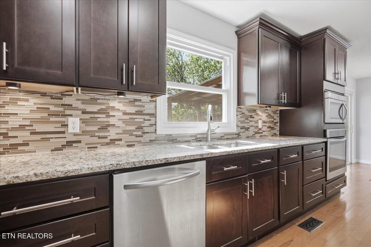7709 Morris Road Knoxville, TN 37938 - Photo 17 of 52 a kitchen with granite countertop stainless steel appliances wooden cabinets and a sink