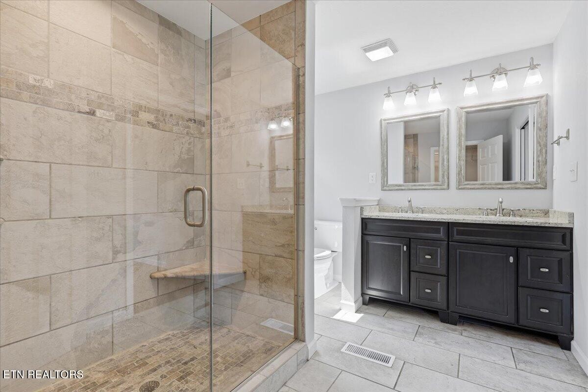 7709 Morris Road Knoxville, TN 37938 - Photo 30 of 52 a bathroom with a granite countertop sink mirror and shower