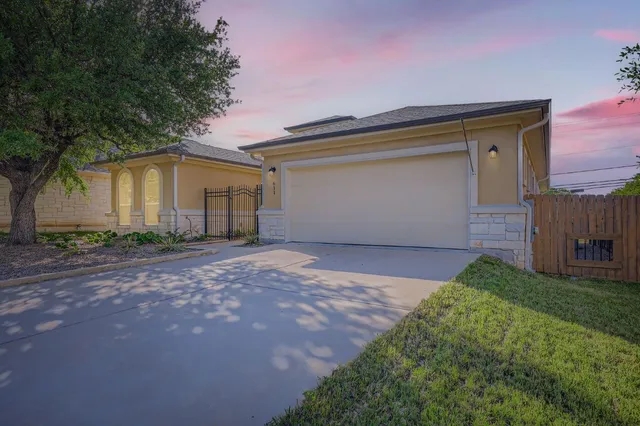 a front view of house with yard and trees in the background