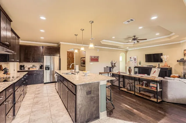 a dining room with furniture a chandelier and wooden floor