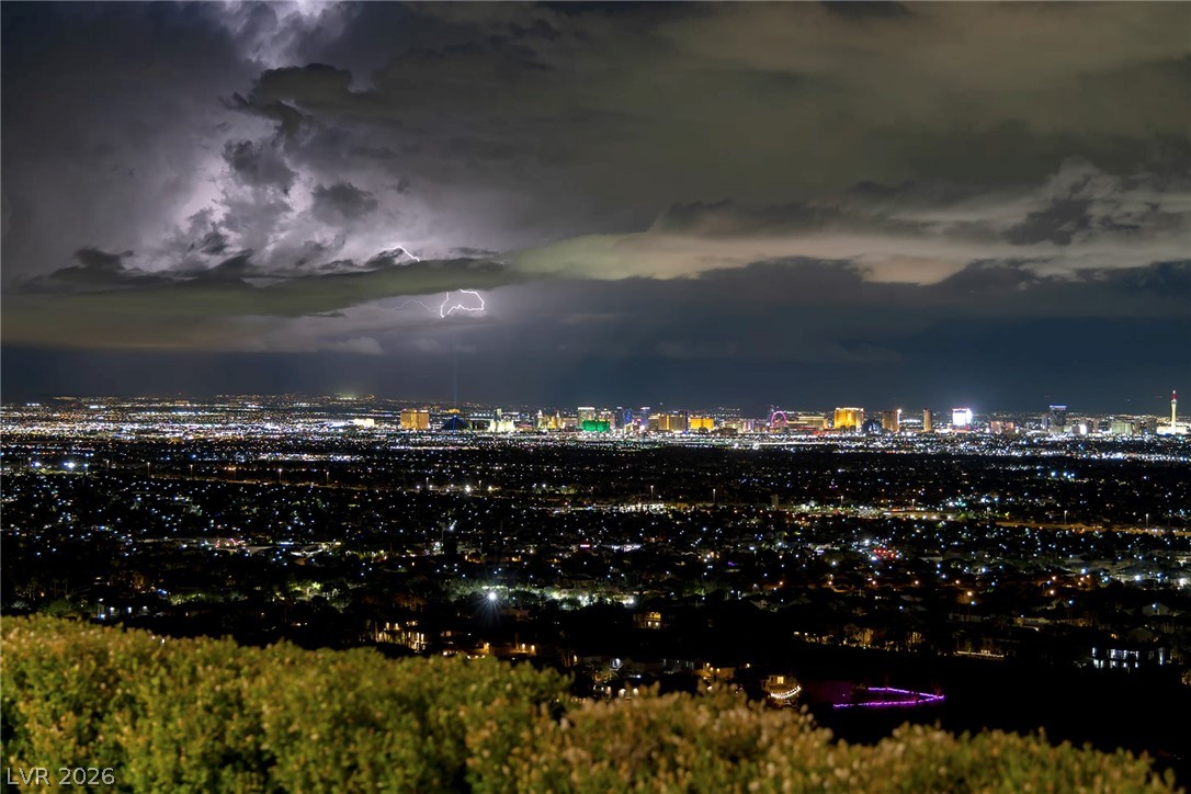 611 Cityview Ridge Drive Henderson, NV 89012 - Photo 41 of 66 Glittering city lights stretch across the horizon under a dramatic, expansive desert sky.