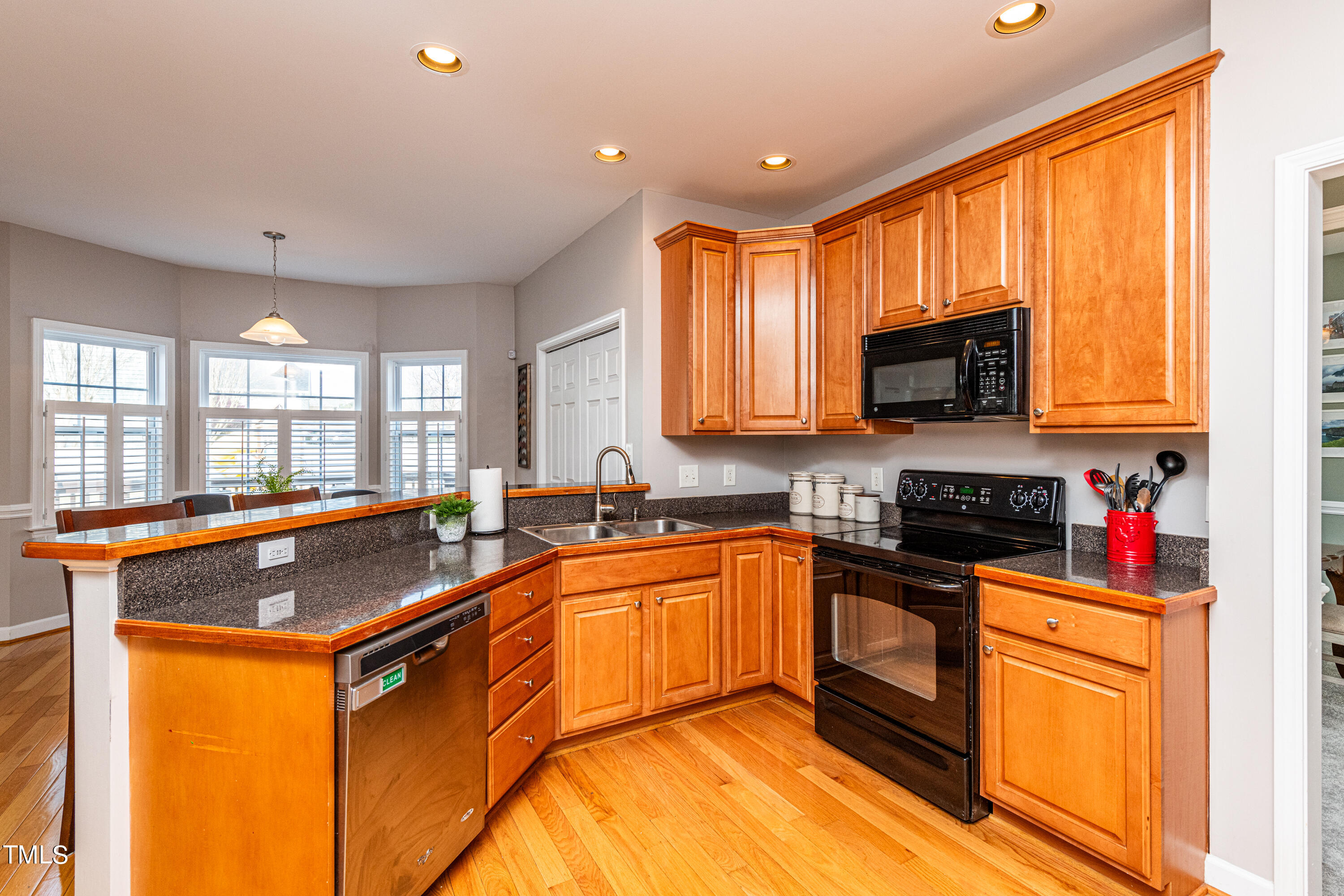 113 Sugarloaf Way Raleigh, NC 27603 - Photo 14 of 42 a kitchen with stainless steel appliances granite countertop wooden cabinets a stove top oven a sink and dishwasher with kitchen island