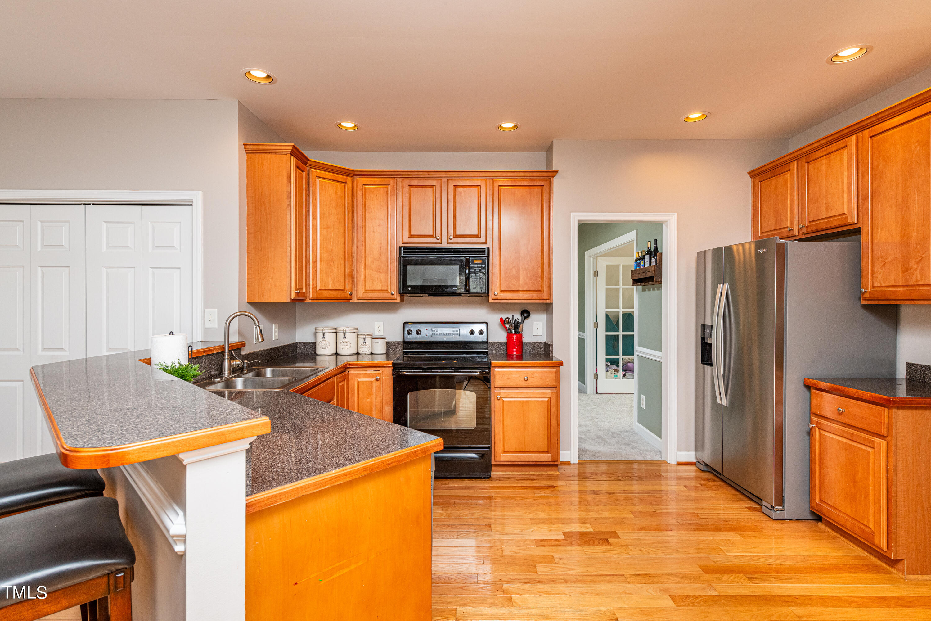 113 Sugarloaf Way Raleigh, NC 27603 - Photo 17 of 42 a kitchen with a refrigerator a stove top oven a sink dishwasher and wooden cabinets