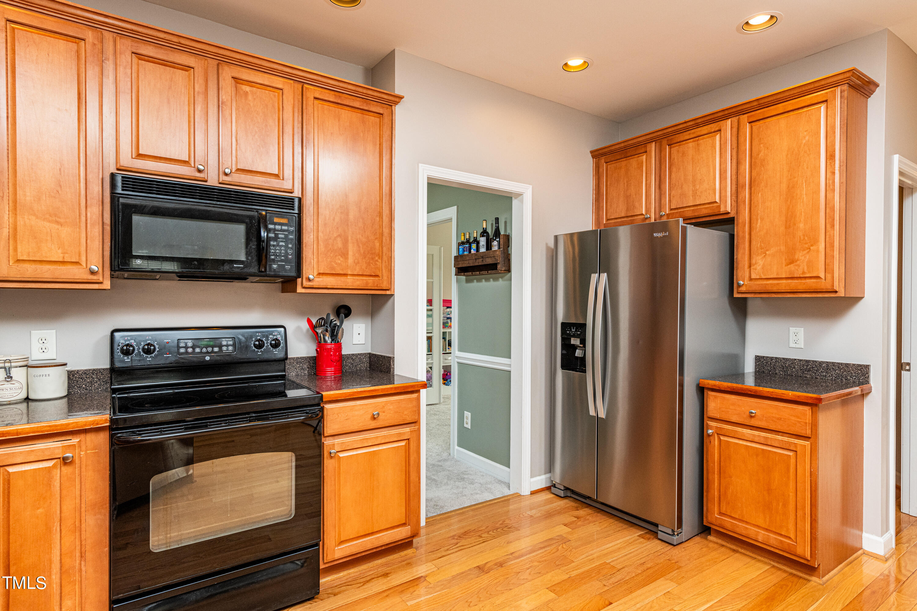 113 Sugarloaf Way Raleigh, NC 27603 - Photo 18 of 42 a kitchen with granite countertop wooden cabinets a stove top oven and refrigerator