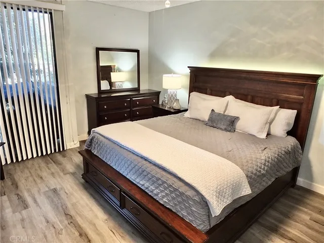 a bedroom with a bed and painting on the wall