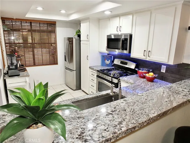 a kitchen with stainless steel appliances granite countertop sink stove and refrigerator
