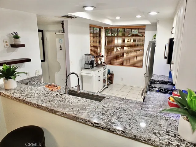 a kitchen with granite countertop stainless steel appliances and sink