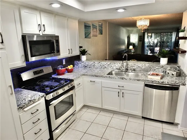 a view of a dining room with furniture a kitchen and wooden floor