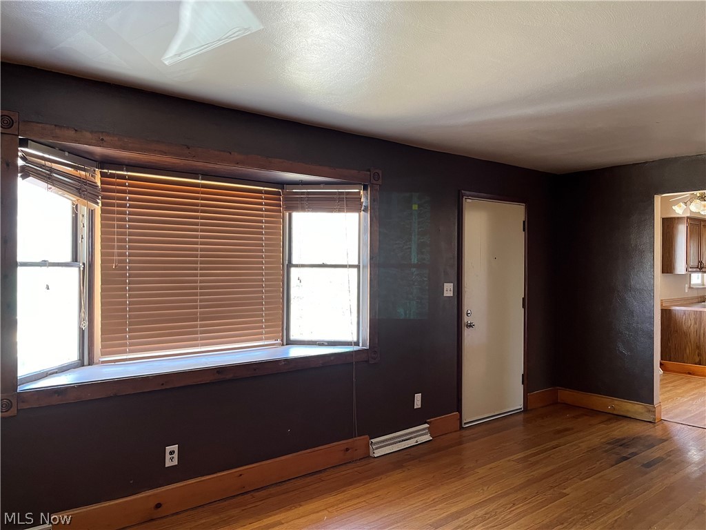 Living room with light hardwood floors & bay window