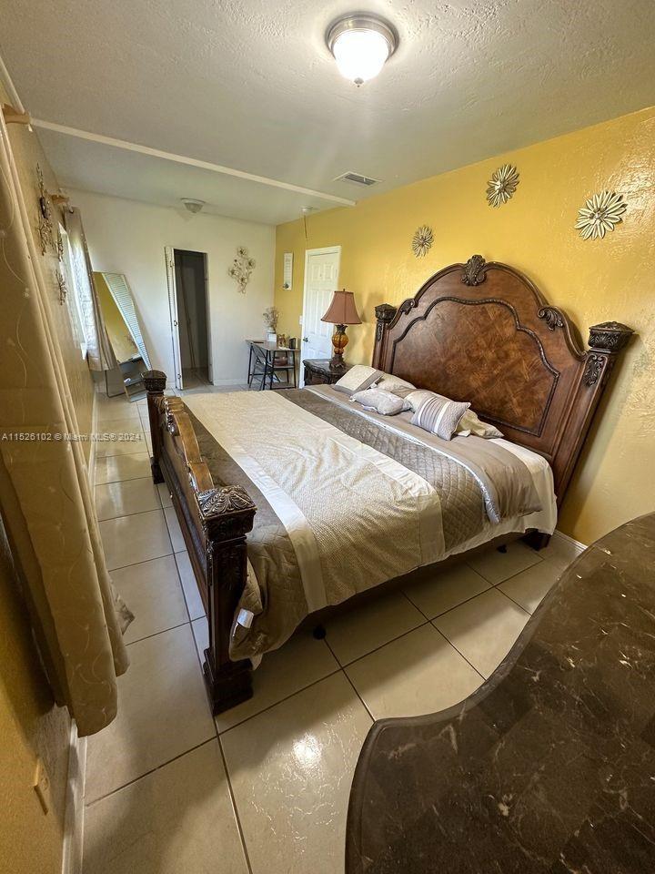 14821 Pierce Street Miami, FL 33176 - Photo 3 of 5 a bedroom with a bed and wooden floor