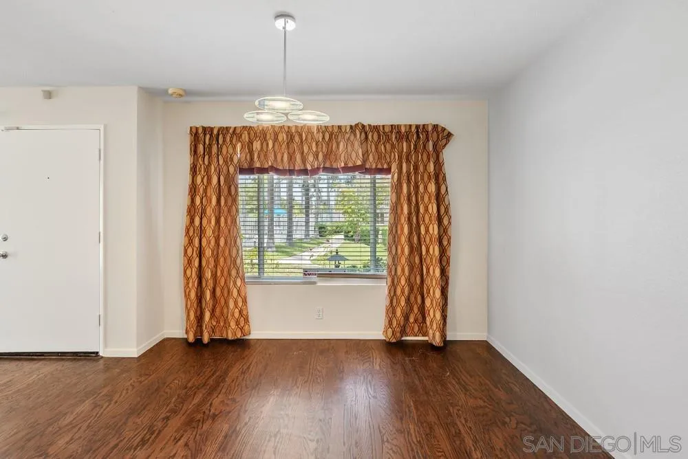219 Diamond Way, Unit 115 Vista, CA 92083 - Photo 13 of 36 an empty room with wooden floor and windows