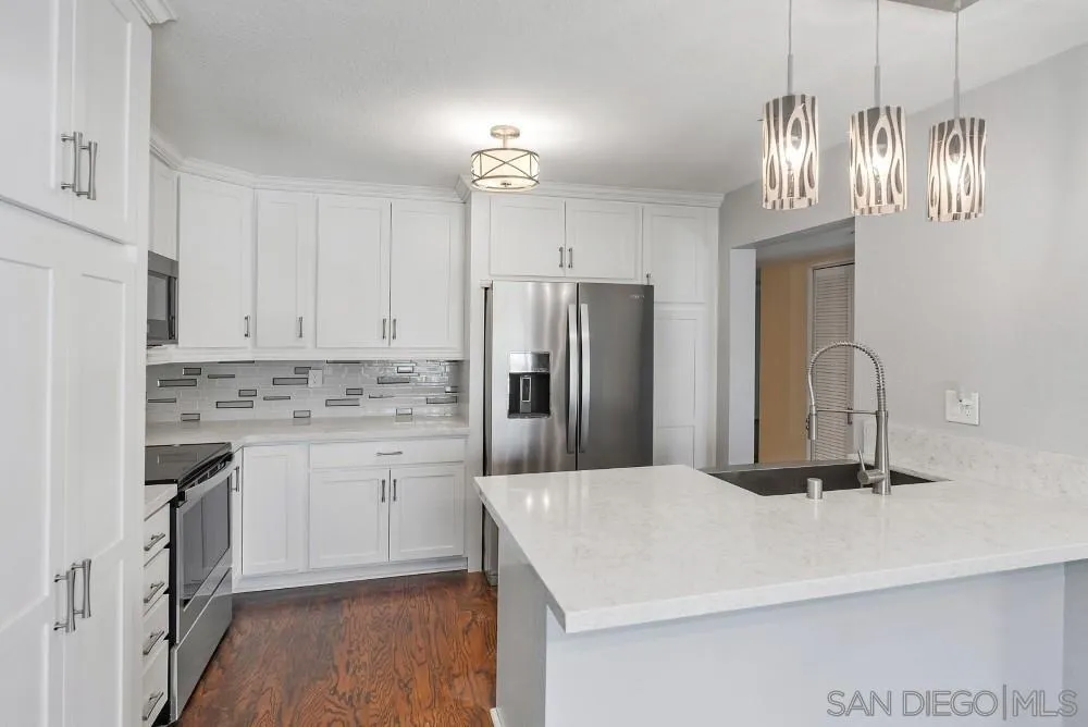219 Diamond Way, Unit 115 Vista, CA 92083 - Photo 16 of 36 a kitchen with a refrigerator sink and cabinets