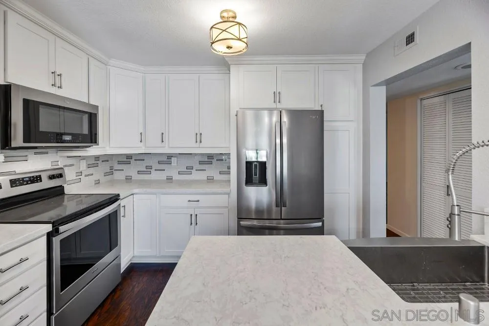 219 Diamond Way, Unit 115 Vista, CA 92083 - Photo 17 of 36 a kitchen with stainless steel appliances a stove microwave and refrigerator