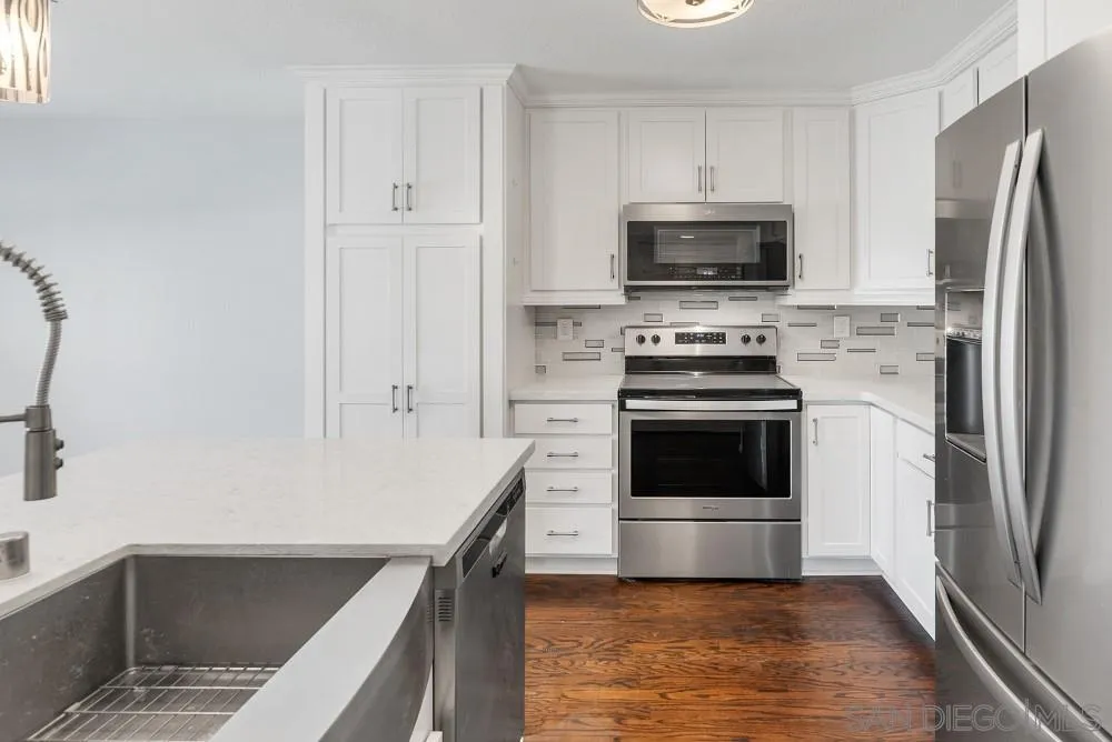 219 Diamond Way, Unit 115 Vista, CA 92083 - Photo 19 of 36 a kitchen with a stove a microwave and a refrigerator