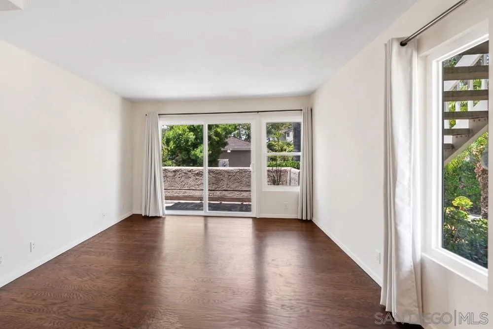 219 Diamond Way, Unit 115 Vista, CA 92083 - Photo 5 of 36 an empty room with wooden floor and windows