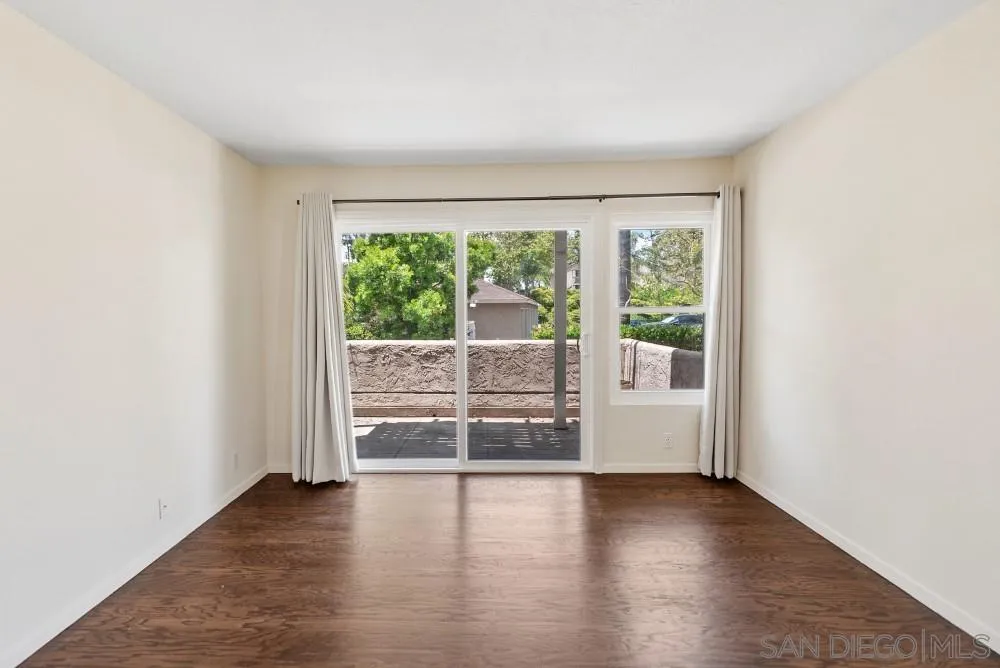 219 Diamond Way, Unit 115 Vista, CA 92083 - Photo 6 of 36 an empty room with wooden floor and windows