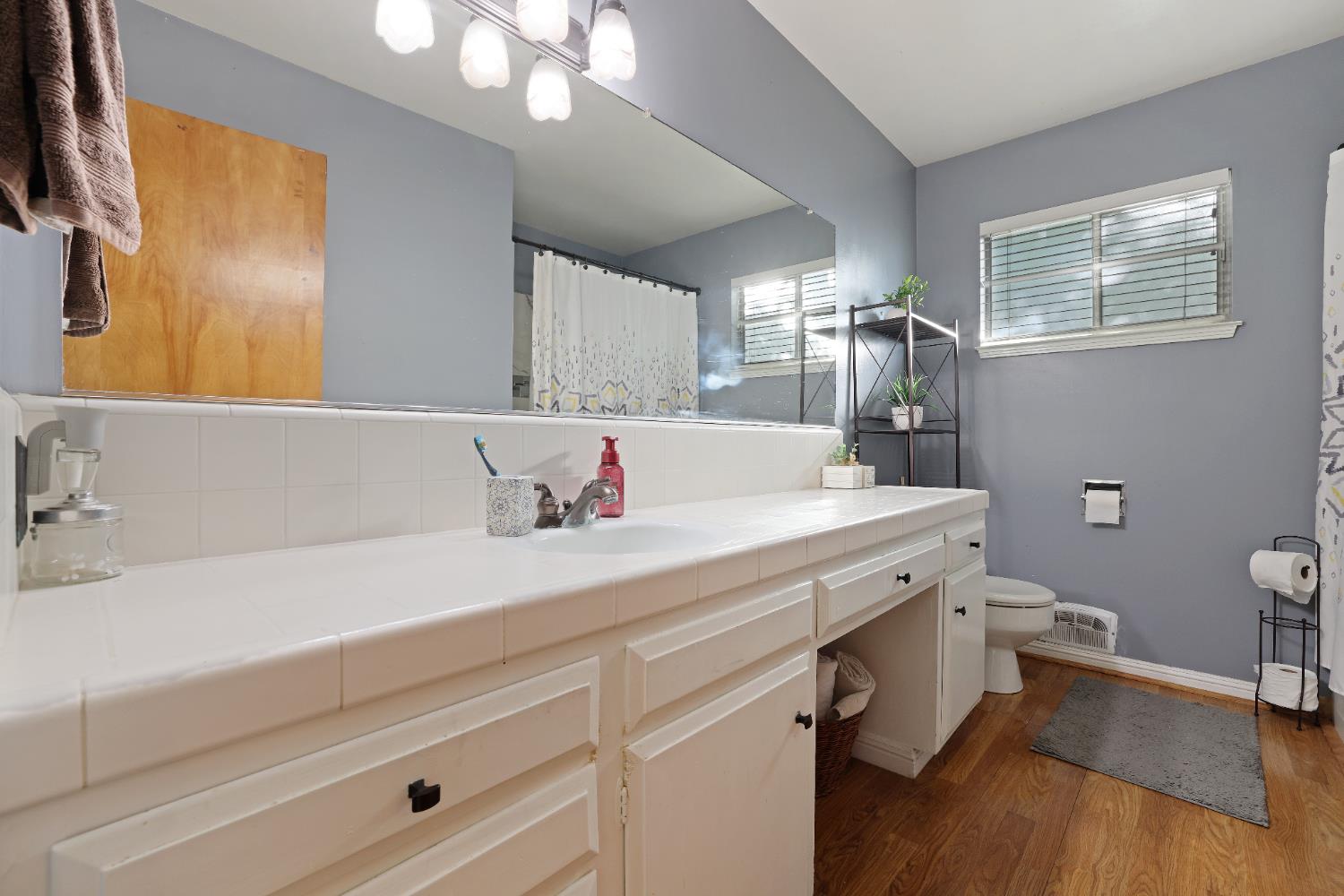 1608 Kruger Drive Modesto, CA 95355 - Photo 15 of 35 a bathroom with a sink a large mirror and a toilet