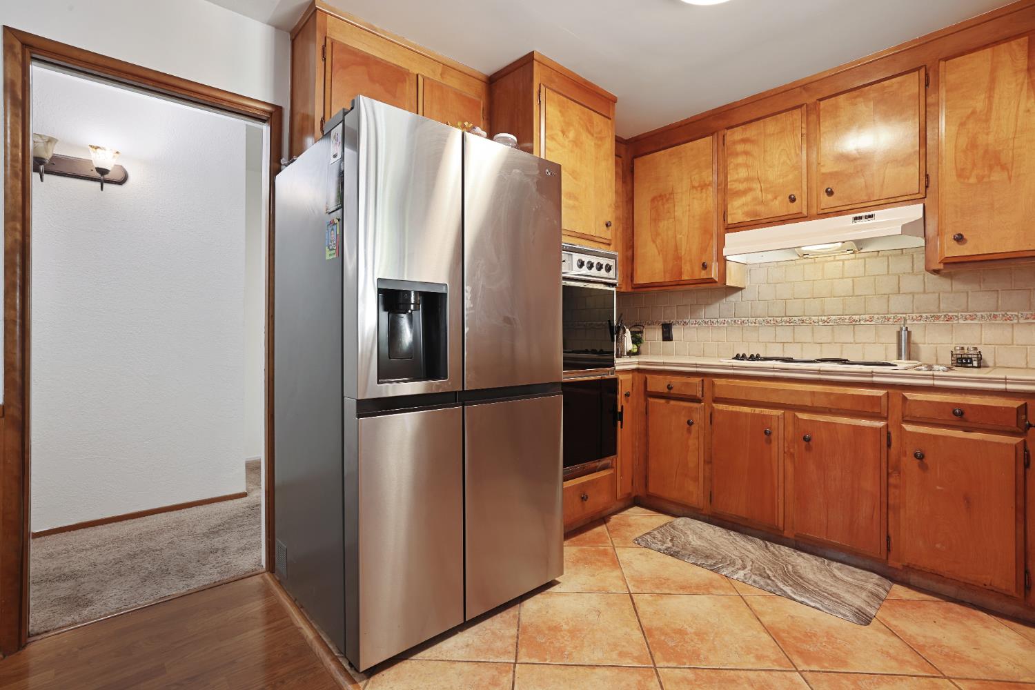 1608 Kruger Drive Modesto, CA 95355 - Photo 25 of 35 a kitchen with stainless steel appliances granite countertop a refrigerator and a sink