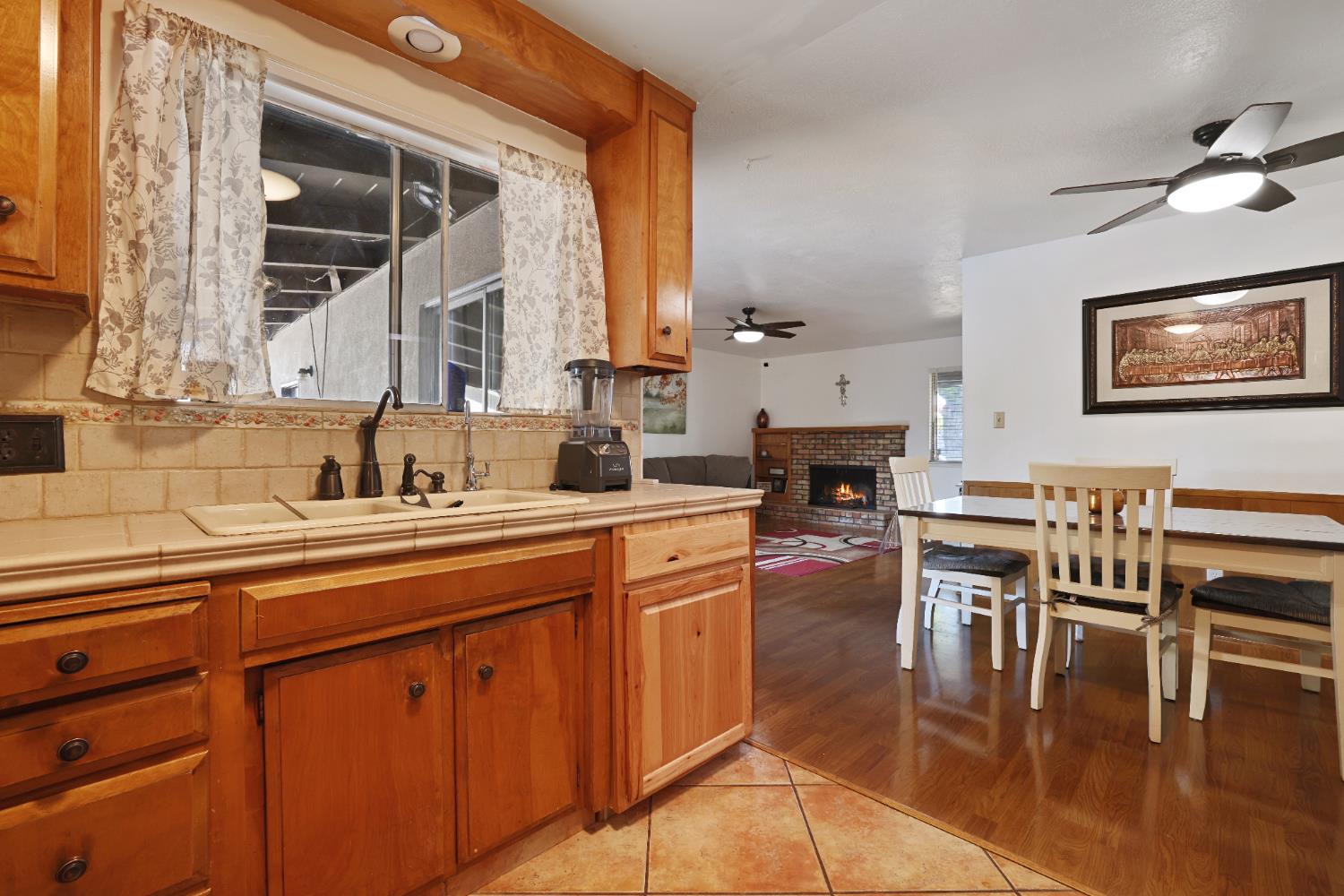 1608 Kruger Drive Modesto, CA 95355 - Photo 26 of 35 a kitchen with stainless steel appliances granite countertop a stove a sink dishwasher and a dining table with wooden floor