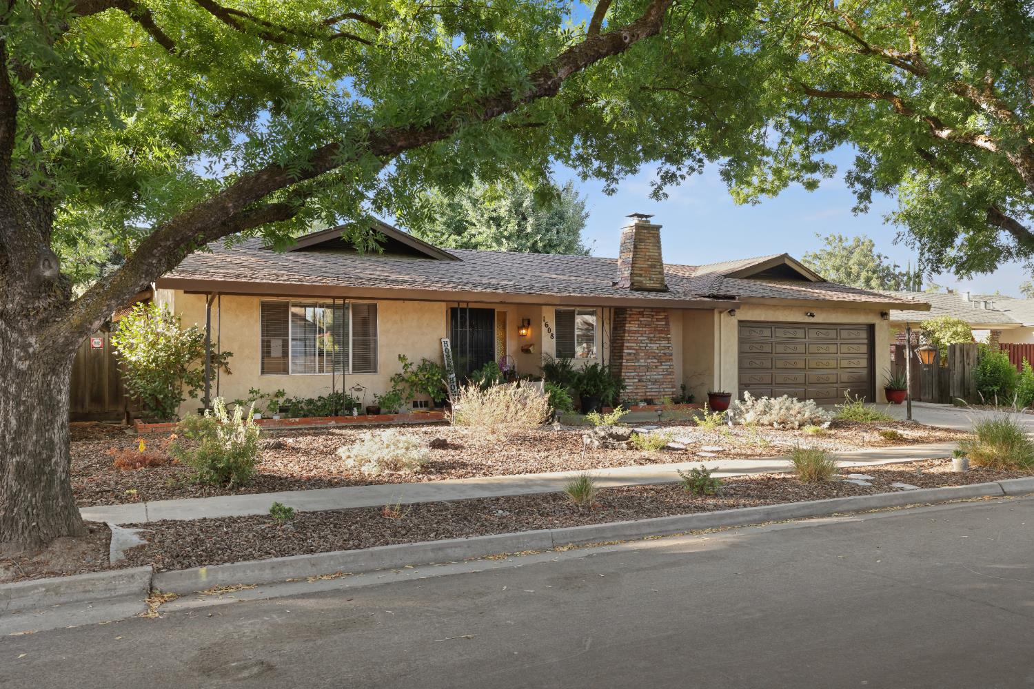 1608 Kruger Drive Modesto, CA 95355 - Photo 4 of 35 a front view of a house with a tree and yard