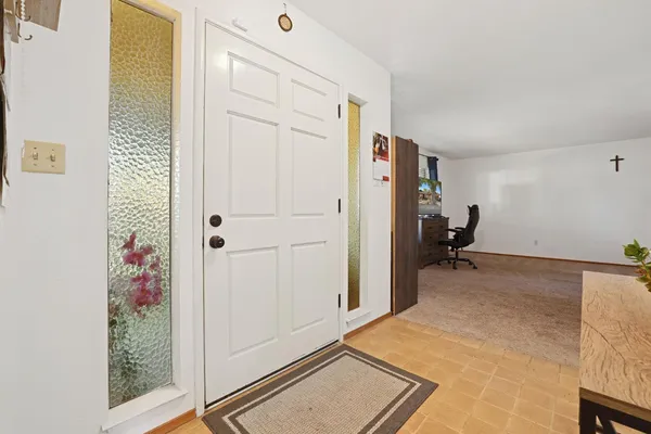 a view of a hallway to a livingroom with furniture