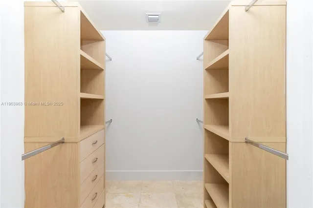 a view of walk in closet with empty racks
