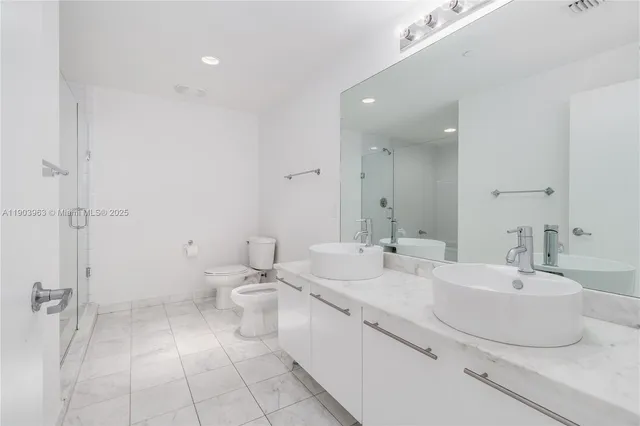 a bathroom with a double vanity sink mirror and toilet