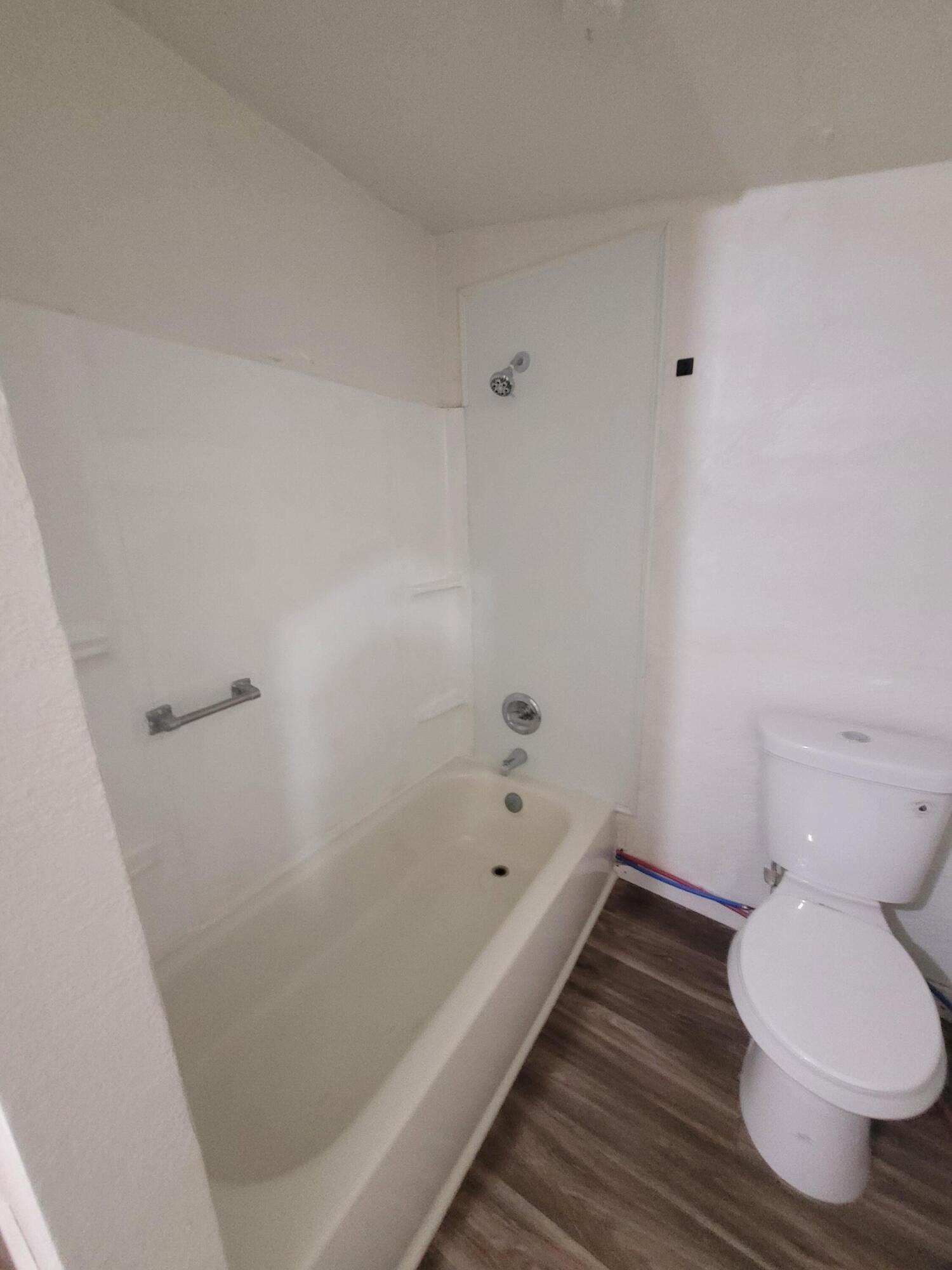 1055 South 3rd Street Slaton, TX 79364 - Photo 11 of 13 a bathroom with a bathtub and toilet