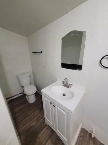 a bathroom with a toilet sink and mirror