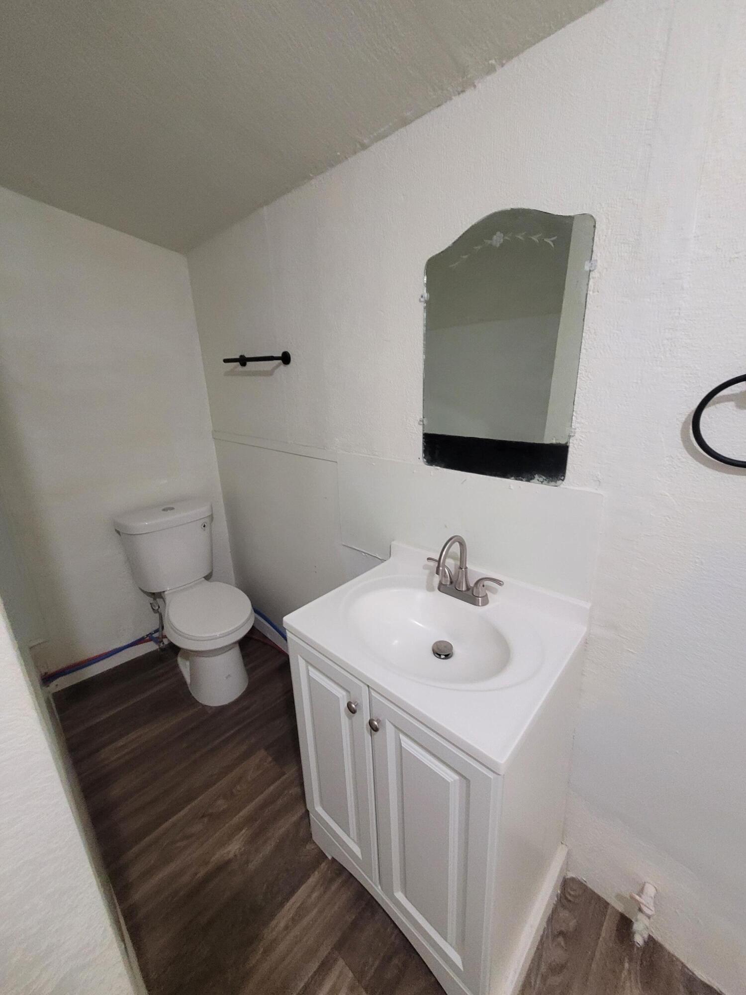 1055 South 3rd Street Slaton, TX 79364 - Photo 12 of 13 a bathroom with a toilet sink and mirror