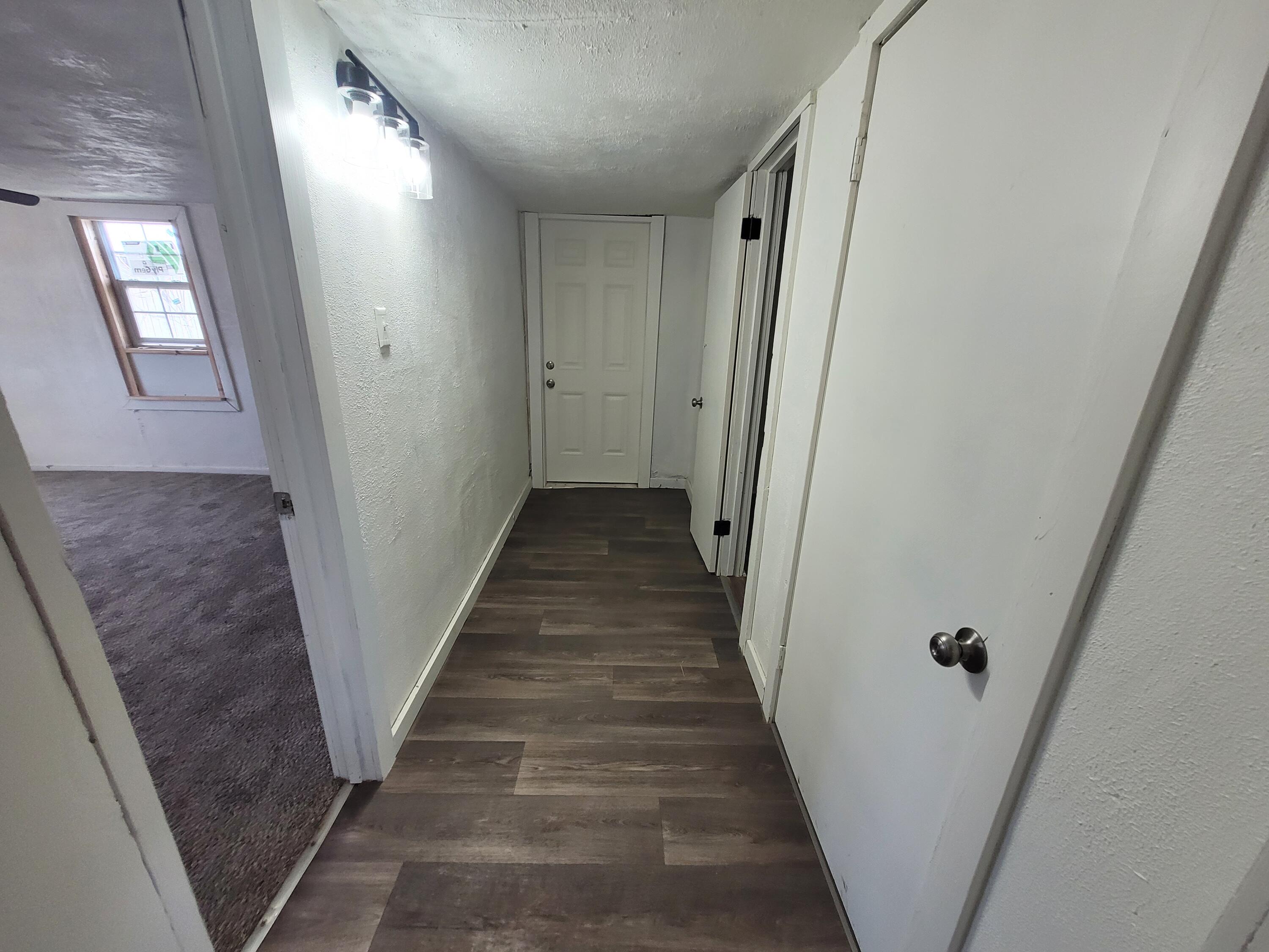 1055 South 3rd Street Slaton, TX 79364 - Photo 5 of 13 a view of a hallway with wooden floor and staircase