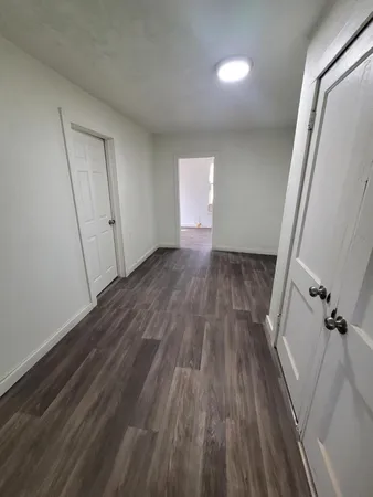 a view of a room with wooden floor and window