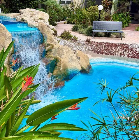 a backyard of a house with lots of green space and fountain