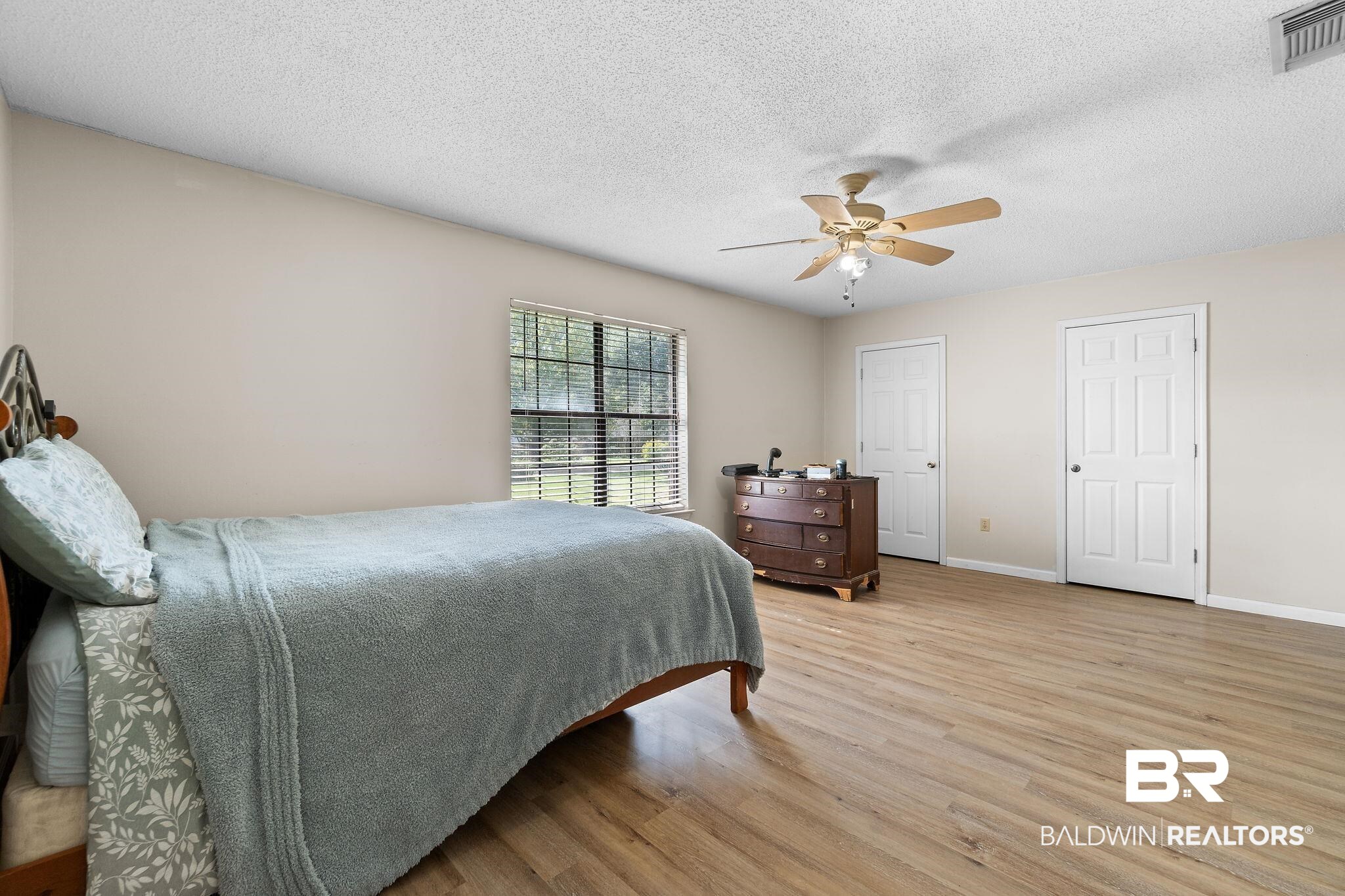 33135 Collier Road Lillian, AL 36549 - Photo 15 of 30 Bedroom featuring a textured ceiling, light wood-type flooring, and ceiling fan