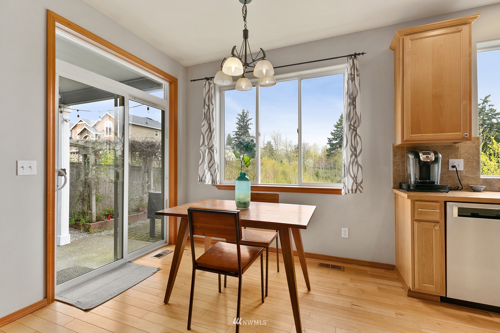 21117 Meridian Place West Bothell, WA 98021 - Photo 3 of 30 a dining room with wooden floor a chandelier a glass table and chairs