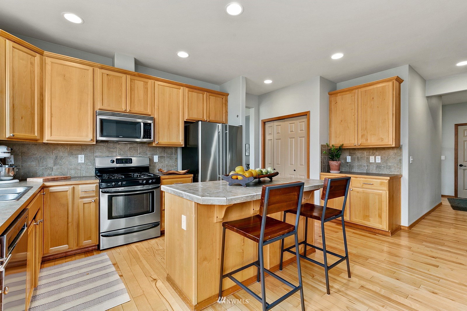 21117 Meridian Place West Bothell, WA 98021 - Photo 5 of 30 a kitchen with stainless steel appliances a stove a sink a refrigerator cabinets and dining table