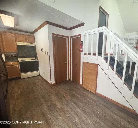 a view of a kitchen with wooden floor and electronic appliances