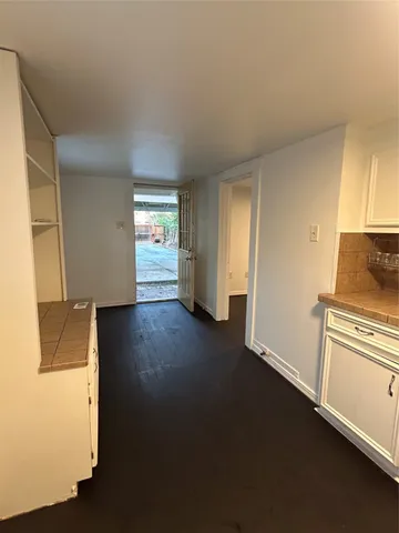 a view of a kitchen with wooden floor and a refrigerator