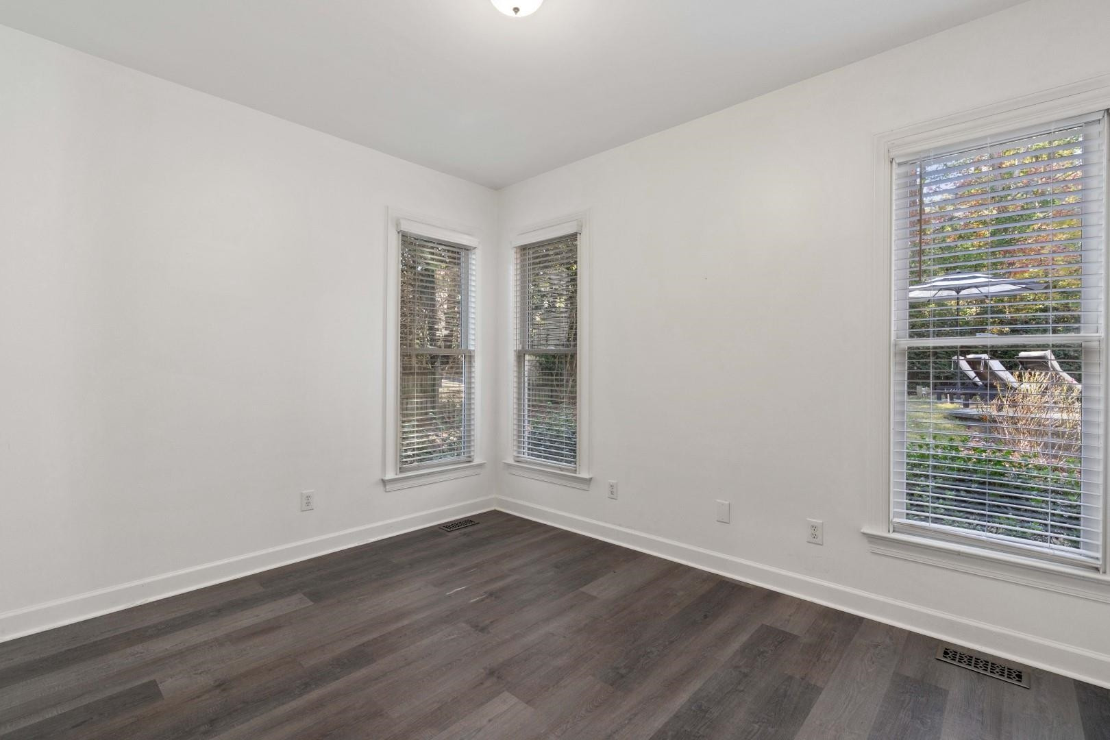 8215 Gadsen Court Raleigh, NC 27613 - Photo 28 of 48 a view of an empty room with wooden floor and a window