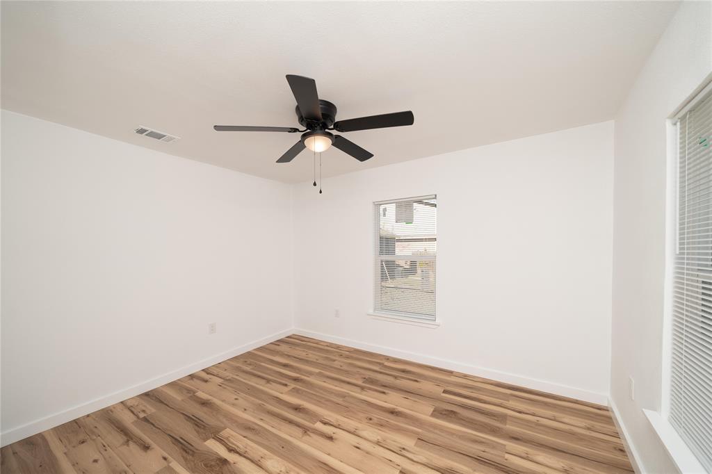 312 North Retta Street Fort Worth, TX 76111 - Photo 15 of 30 a view of empty room with wooden floor and fan