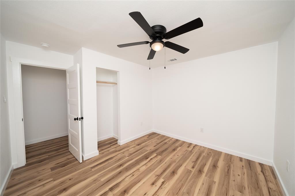 312 North Retta Street Fort Worth, TX 76111 - Photo 16 of 30 an empty room with wooden floor and windows
