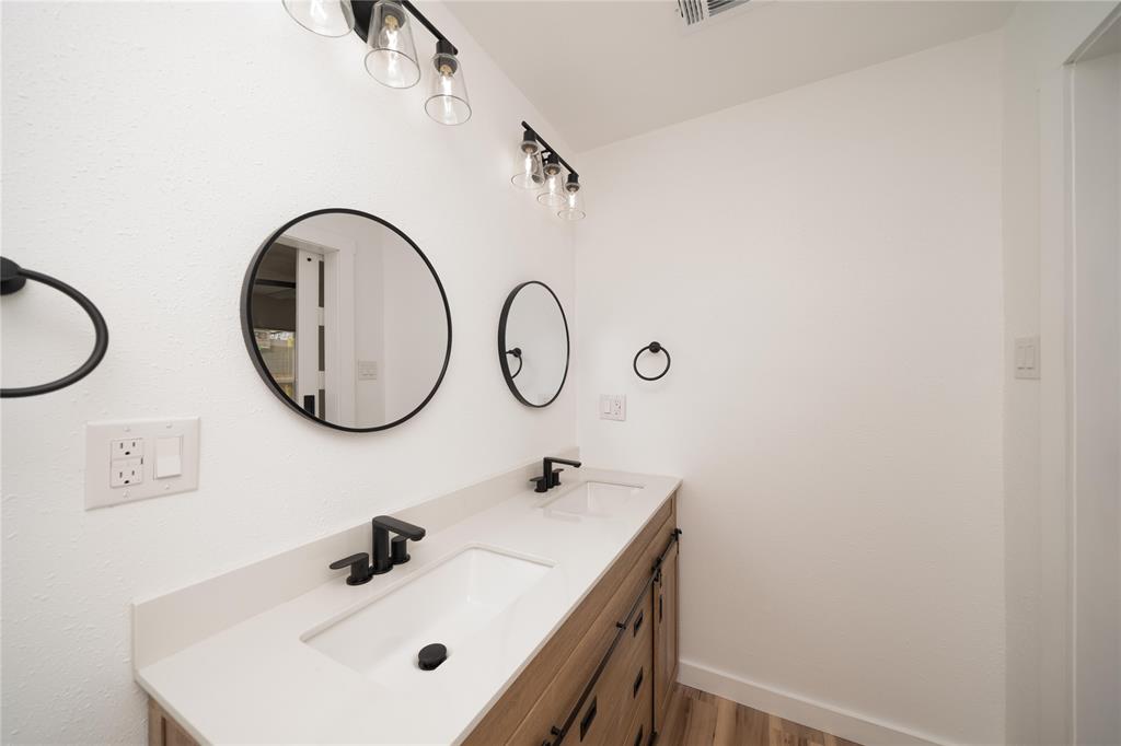 312 North Retta Street Fort Worth, TX 76111 - Photo 21 of 30 a bathroom with a sink and a mirror