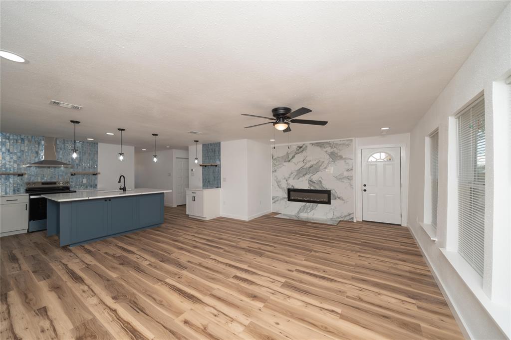 312 North Retta Street Fort Worth, TX 76111 - Photo 5 of 30 a large room with a lot of kitchen furniture and a wooden floor